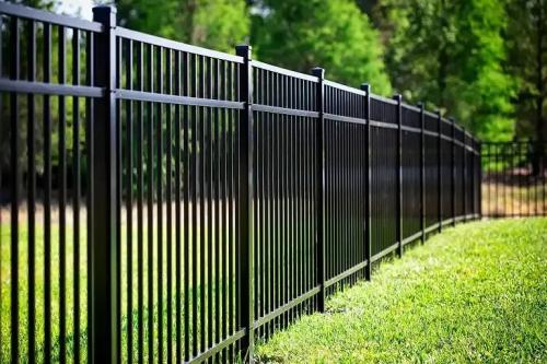 Custom black aluminum residential fencing along a manicured lawn.